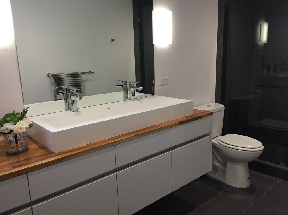Photo of a medium sized scandinavian bathroom in Los Angeles with a vessel sink, flat-panel cabinets, white cabinets, wooden worktops, grey tiles, ceramic tiles, white walls and ceramic flooring.