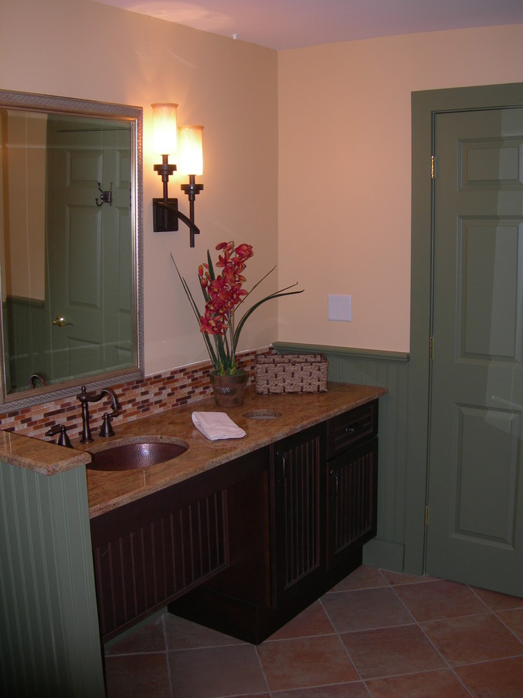 Inspiration pour une salle de bain traditionnelle en bois foncé de taille moyenne avec un lavabo encastré, un placard avec porte à panneau encastré, un plan de toilette en granite, un carrelage multicolore, des plaques de verre, un mur orange et un sol en carrelage de céramique.