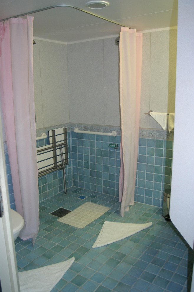 Bild på ett vintage badrum, med ett väggmonterat handfat, en kantlös dusch, blå kakel, keramikplattor, blå väggar och klinkergolv i keramik