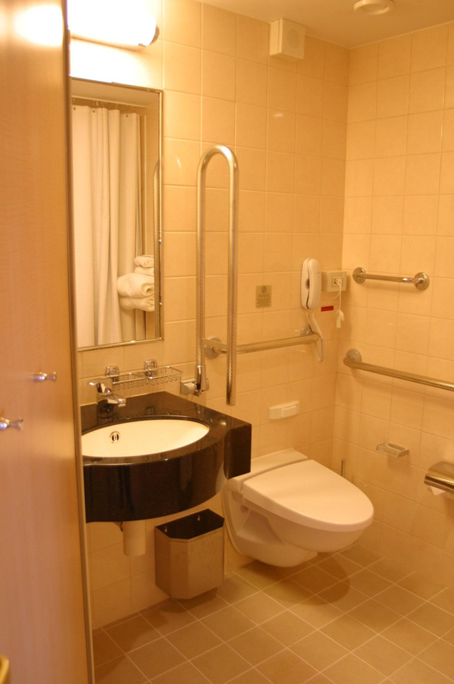 Esempio di una stanza da bagno minimalista con lavabo sospeso, top in granito, WC sospeso, piastrelle beige, piastrelle in ceramica, pareti beige e pavimento con piastrelle in ceramica