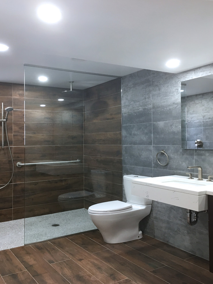 Design ideas for a large contemporary bathroom in New York with dark wood cabinets, a walk-in shower, a two-piece toilet, grey tiles, porcelain tiles, grey walls, porcelain flooring, a submerged sink and engineered stone worktops.