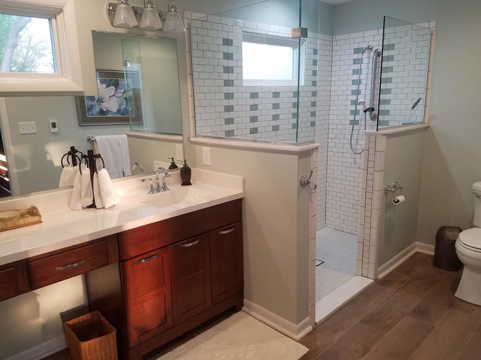 Inspiration for a large beach style ensuite bathroom in Indianapolis with shaker cabinets, dark wood cabinets, a corner shower, a two-piece toilet, green tiles, white tiles, metro tiles, green walls, porcelain flooring, a submerged sink, engineered stone worktops, brown floors and an open shower.