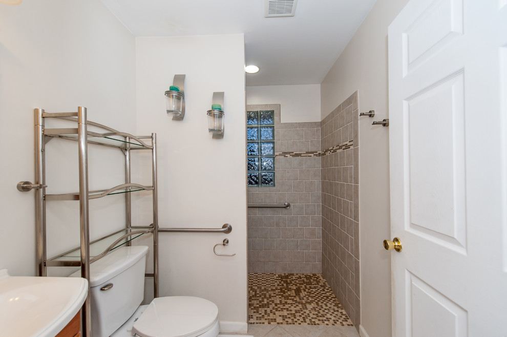 Mittelgroßes Klassisches Duschbad mit profilierten Schrankfronten, hellen Holzschränken, Duschnische, Wandtoilette mit Spülkasten, weißer Wandfarbe, Keramikboden, Einbauwaschbecken, grauem Boden und offener Dusche in Baltimore