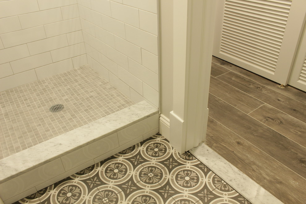 ニューヨークにある高級な小さなカントリー風のおしゃれな子供用バスルーム (家具調キャビネット、ヴィンテージ仕上げキャビネット、アルコーブ型シャワー、分離型トイレ、白いタイル、サブウェイタイル、グレーの壁、セラミックタイルの床、アンダーカウンター洗面器、大理石の洗面台、ベージュの床) の写真