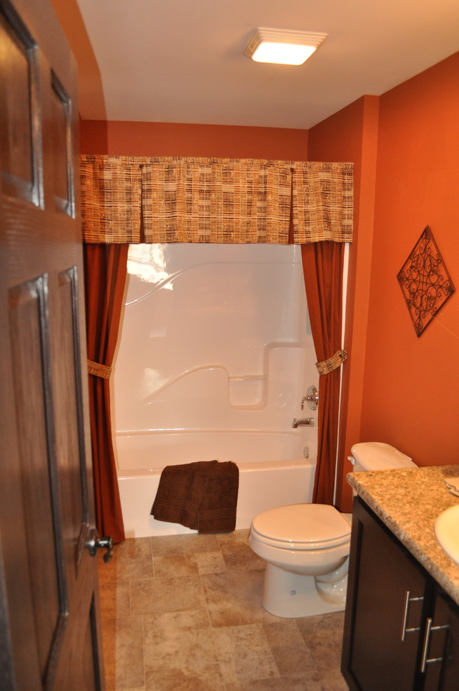 Cette image montre une salle de bain design en bois foncé de taille moyenne pour enfant avec un plan vasque, un placard avec porte à panneau encastré, un combiné douche/baignoire, WC à poser, un carrelage beige, un mur orange, un sol en carrelage de céramique et des carreaux de céramique.