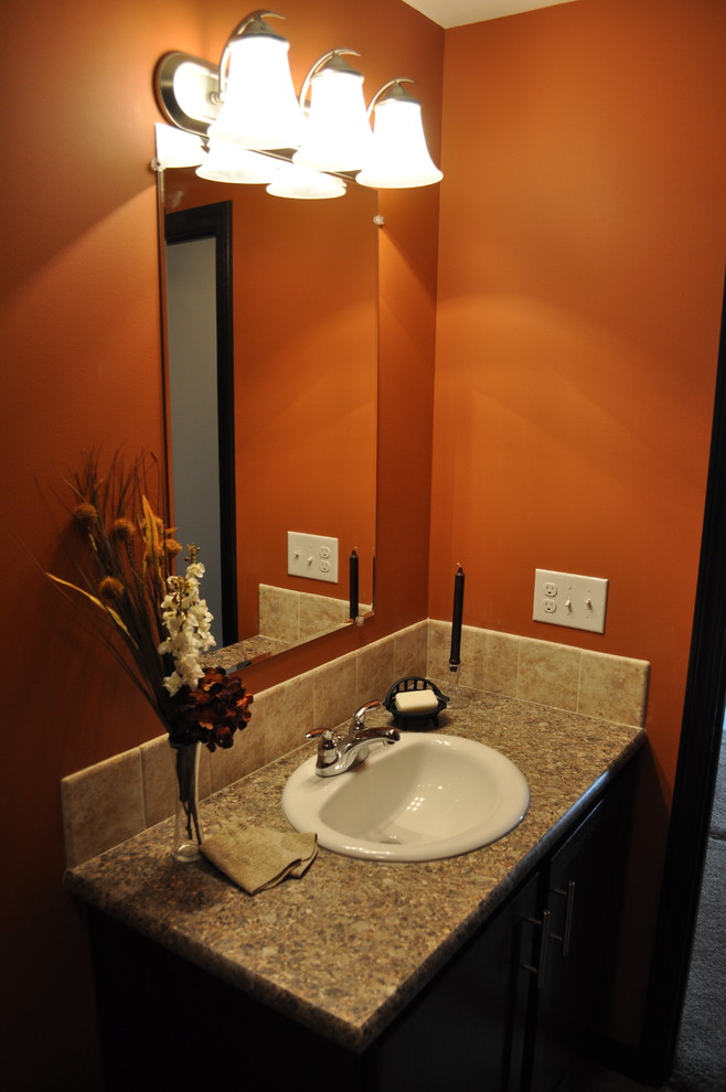 Cette image montre une salle de bain design en bois foncé de taille moyenne pour enfant avec un plan vasque, un placard avec porte à panneau encastré, un combiné douche/baignoire, WC à poser, un carrelage beige, des carreaux de céramique, un mur orange et un sol en carrelage de céramique.