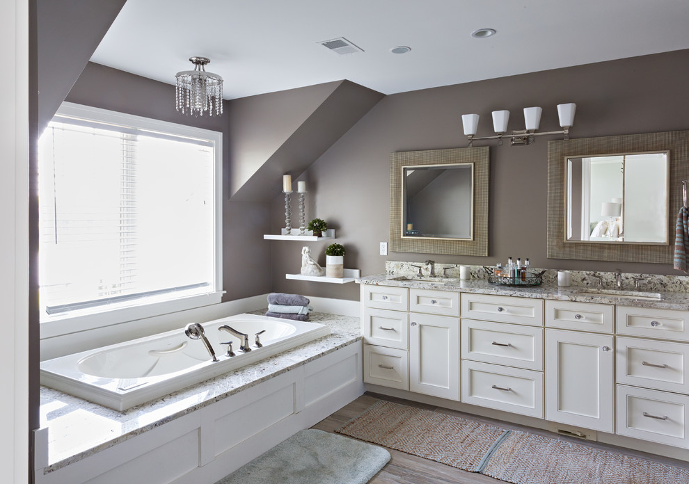 デトロイトにあるトランジショナルスタイルのおしゃれなマスターバスルーム (インセット扉のキャビネット、白いキャビネット、アルコーブ型浴槽、茶色い壁、淡色無垢フローリング、アンダーカウンター洗面器、照明) の写真