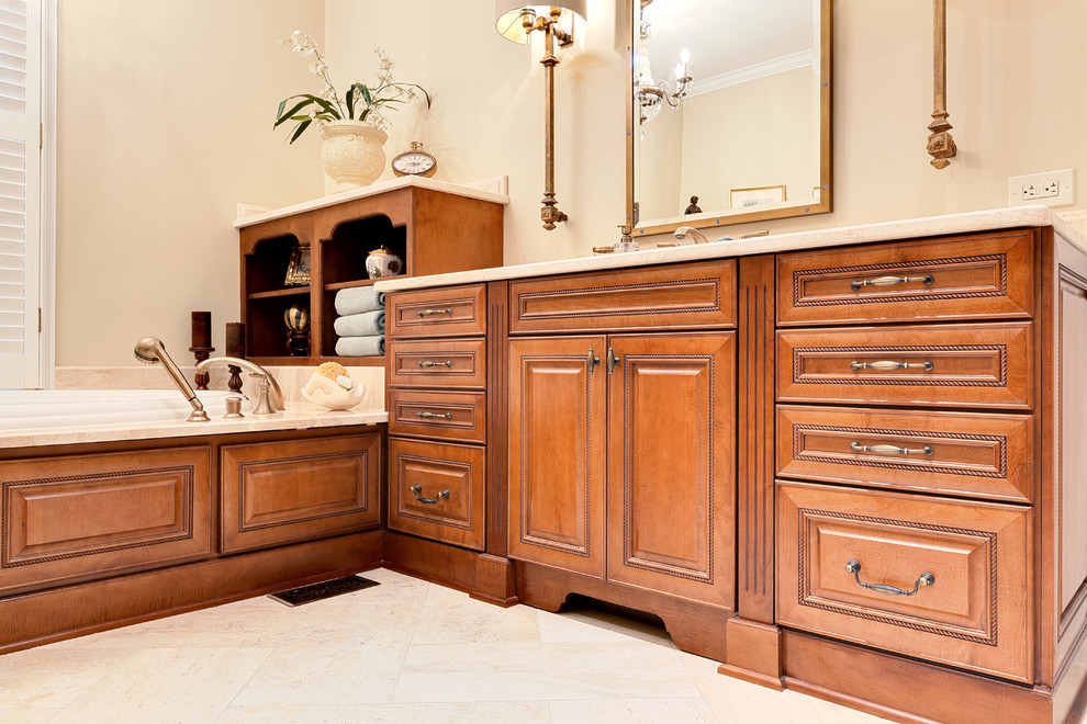 This is an example of an expansive classic ensuite bathroom in Atlanta with raised-panel cabinets, medium wood cabinets, a built-in bath, a corner shower, a two-piece toilet, beige walls, porcelain flooring, a submerged sink, marble worktops, beige floors, a hinged door, beige worktops, an enclosed toilet, double sinks and a built in vanity unit.