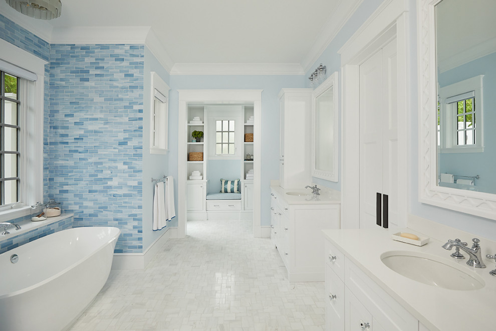 Идея дизайна: огромная главная ванная комната в морском стиле с фасадами в стиле шейкер, белыми фасадами, отдельно стоящей ванной, синей плиткой, керамогранитной плиткой, синими стенами, врезной раковиной, серым полом, белой столешницей, тумбой под одну раковину и встроенной тумбой