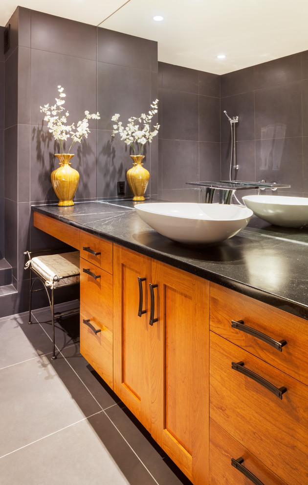 This is an example of a traditional ensuite bathroom in Boston with a vessel sink, medium wood cabinets, soapstone worktops, brown tiles, stone tiles and slate flooring.