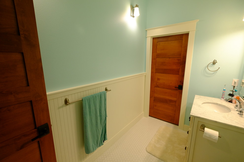 Foto på ett mellanstort maritimt en-suite badrum, med ett konsol handfat, möbel-liknande, skåp i slitet trä, marmorbänkskiva, en dusch i en alkov, vit kakel, mosaik, blå väggar och klinkergolv i porslin