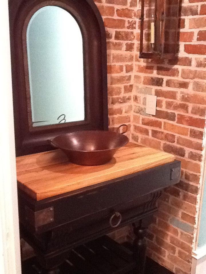 Foto de cuarto de baño clásico pequeño con lavabo sobreencimera, puertas de armario negras, encimera de madera, suelo de madera oscura, aseo y ducha y baldosas y/o azulejos rojos