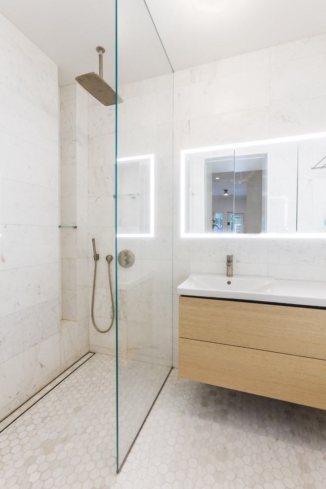 Réalisation d'une salle de bain principale nordique en bois clair de taille moyenne avec un placard en trompe-l'oeil, une douche ouverte, WC suspendus, un carrelage blanc, du carrelage en marbre, un sol en marbre, un lavabo suspendu et aucune cabine.