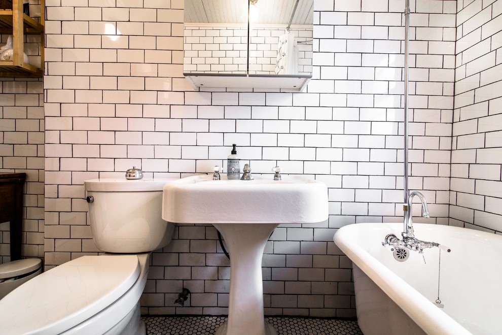 ニューヨークにある小さなミッドセンチュリースタイルのおしゃれな浴室 (ペデスタルシンク、猫足バスタブ、シャワー付き浴槽	、分離型トイレ、白いタイル、磁器タイル、ベージュの壁、淡色無垢フローリング) の写真