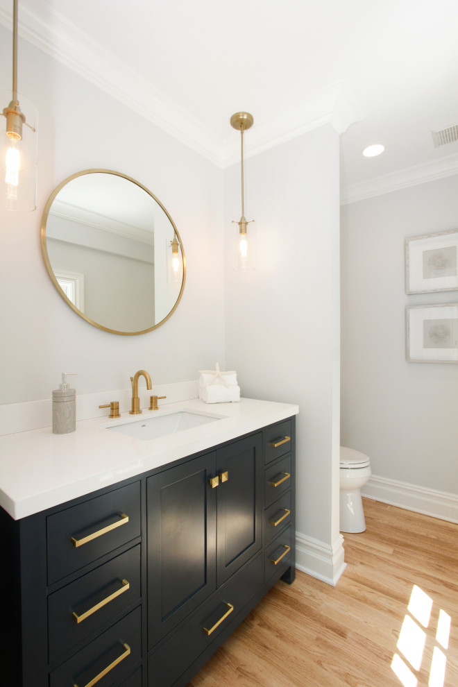 Inspiration for a small classic shower room bathroom in New York with flat-panel cabinets, black cabinets, a one-piece toilet, white walls, medium hardwood flooring, beige floors, white worktops, a single sink and a freestanding vanity unit.