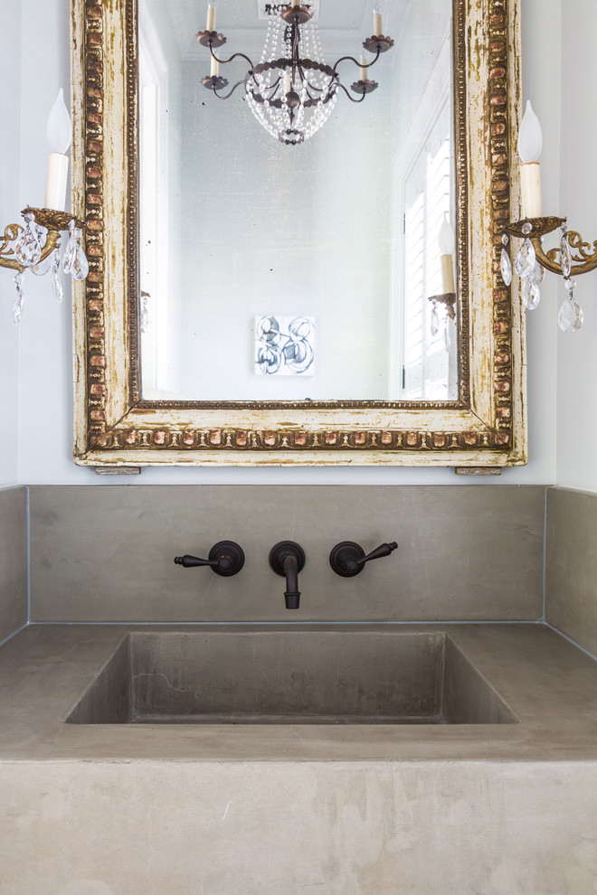 Imagen de cuarto de baño romántico de tamaño medio con paredes blancas, aseo y ducha, lavabo integrado y encimera de cemento