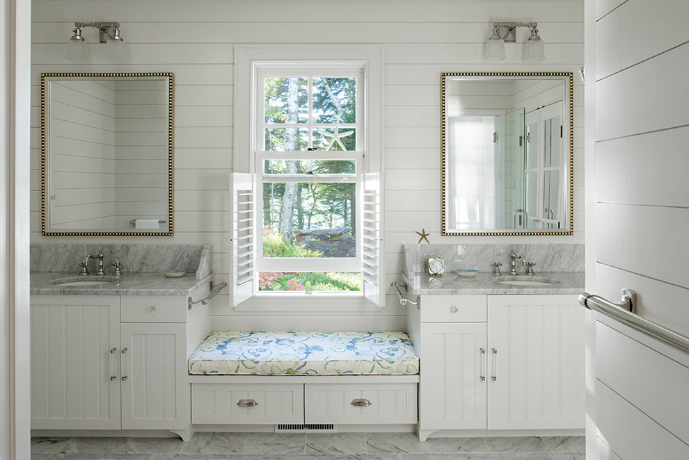 ポートランド(メイン)にあるビーチスタイルのおしゃれな浴室 (アンダーカウンター洗面器、落し込みパネル扉のキャビネット、白いキャビネット、白い壁) の写真