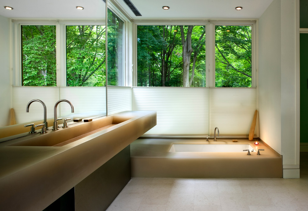 Modelo de cuarto de baño principal contemporáneo con bañera encastrada sin remate, paredes blancas, lavabo integrado, suelo de piedra caliza y ventanas