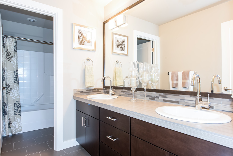 Photo of a medium sized contemporary family bathroom in Seattle with a built-in sink, flat-panel cabinets, dark wood cabinets, tiled worktops, an alcove bath, an alcove shower, a two-piece toilet, grey tiles, ceramic tiles, grey walls and ceramic flooring.