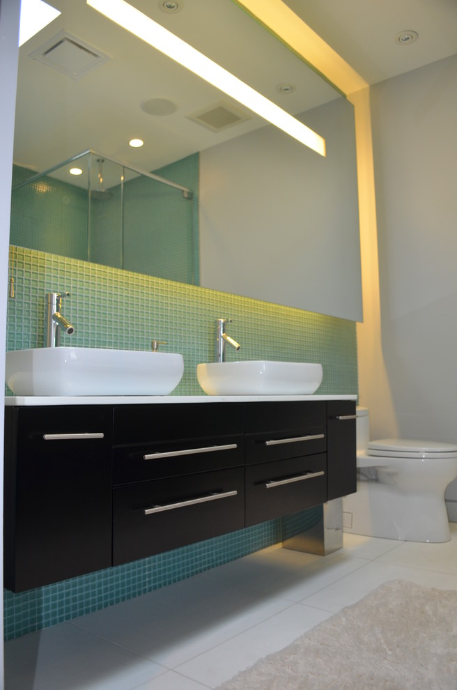 Exemple d'une salle de bain tendance en bois foncé de taille moyenne avec un placard à porte plane, WC à poser, un carrelage bleu, un carrelage vert, mosaïque, un mur gris, un sol en carrelage de porcelaine et une vasque.