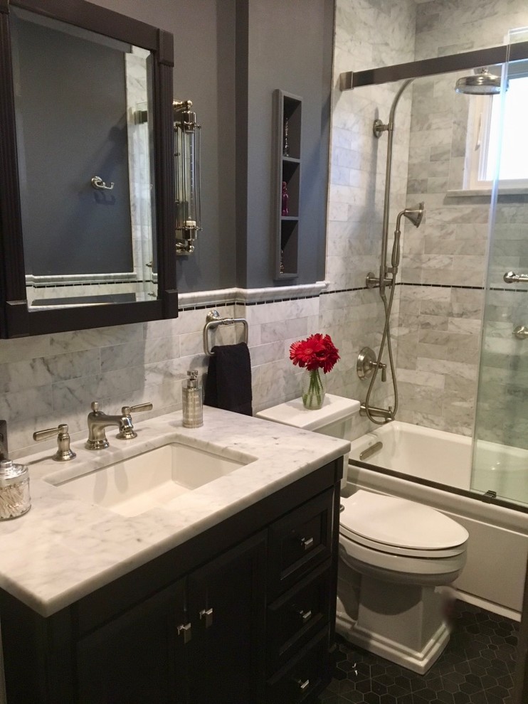 Inspiration for a medium sized traditional family bathroom in New York with black cabinets, an alcove bath, a shower/bath combination, black and white tiles, marble tiles, a submerged sink, marble worktops, a sliding door, recessed-panel cabinets, a one-piece toilet, white worktops, grey walls, mosaic tile flooring and black floors.