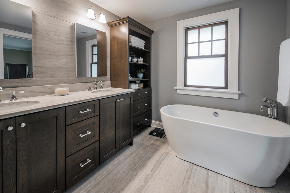 Example of a small transitional 3/4 gray tile and ceramic tile ceramic tile bathroom design in Columbus with shaker cabinets, dark wood cabinets, a two-piece toilet, gray walls, an undermount sink and quartzite countertops