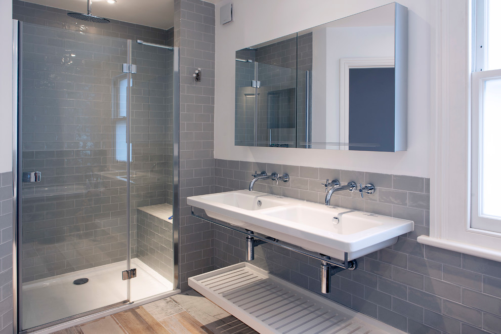 ロンドンにあるコンテンポラリースタイルのおしゃれな浴室 (オープンシェルフ、アルコーブ型シャワー、サブウェイタイル、一体型シンク、ベージュの床、開き戸のシャワー、白い洗面カウンター) の写真
