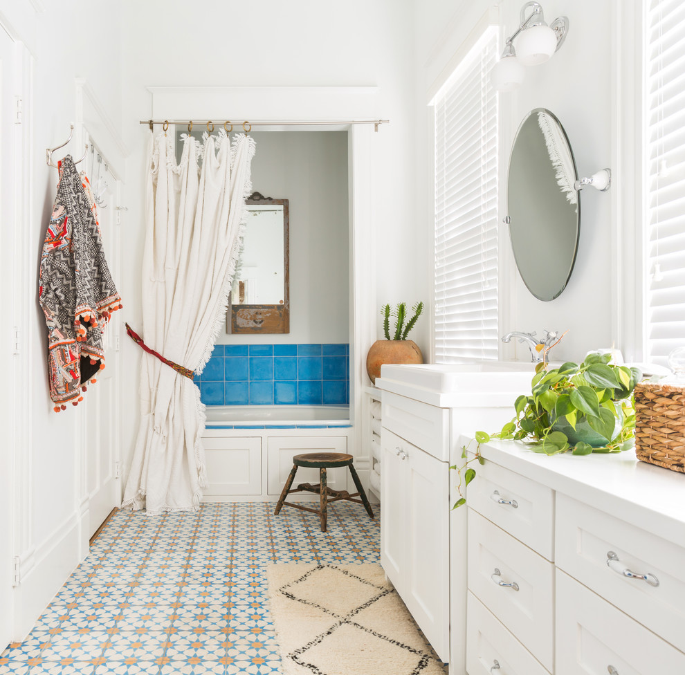 На фото: главная ванная комната среднего размера в средиземноморском стиле с фасадами в стиле шейкер, белыми фасадами, синей плиткой, разноцветной плиткой, белыми стенами, разноцветным полом, ванной в нише, душем в нише, керамической плиткой, полом из керамической плитки, накладной раковиной, душем с распашными дверями и зеркалом с подсветкой