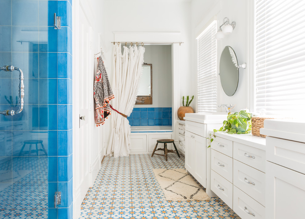 Modelo de cuarto de baño principal de estilo americano de tamaño medio con armarios estilo shaker, puertas de armario blancas, baldosas y/o azulejos azules, paredes blancas, ducha con puerta con bisagras, bañera empotrada, ducha empotrada, baldosas y/o azulejos de cerámica, suelo de baldosas de cerámica, lavabo encastrado y suelo multicolor