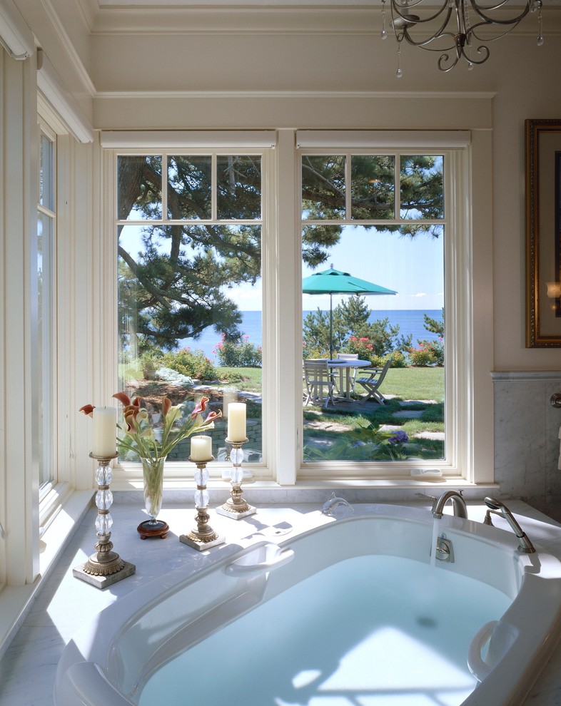 На фото: большая главная ванная комната в викторианском стиле с угловой ванной и белой плиткой с