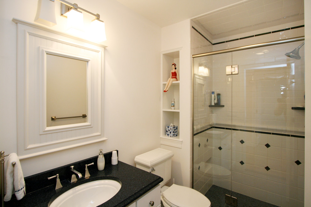 Foto di una stanza da bagno con doccia chic di medie dimensioni con lavabo sottopiano, top in granito, ante lisce, ante bianche, doccia ad angolo, pistrelle in bianco e nero e piastrelle in ceramica