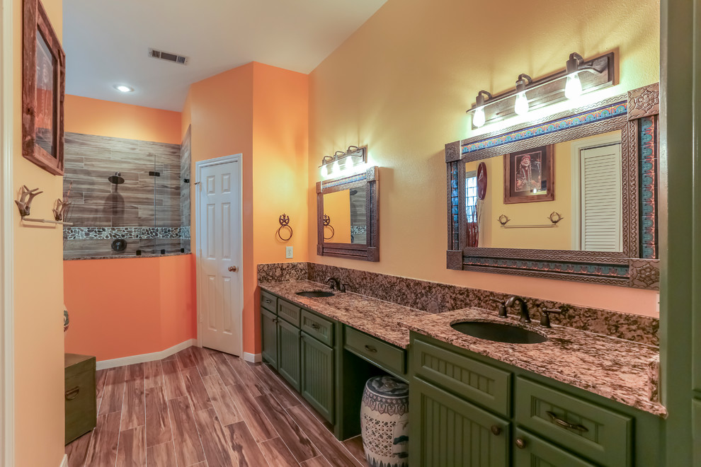 Exempel på ett stort amerikanskt en-suite badrum, med luckor med profilerade fronter, gröna skåp, en öppen dusch, en toalettstol med separat cisternkåpa, brun kakel, porslinskakel, orange väggar, klinkergolv i porslin, ett undermonterad handfat och granitbänkskiva