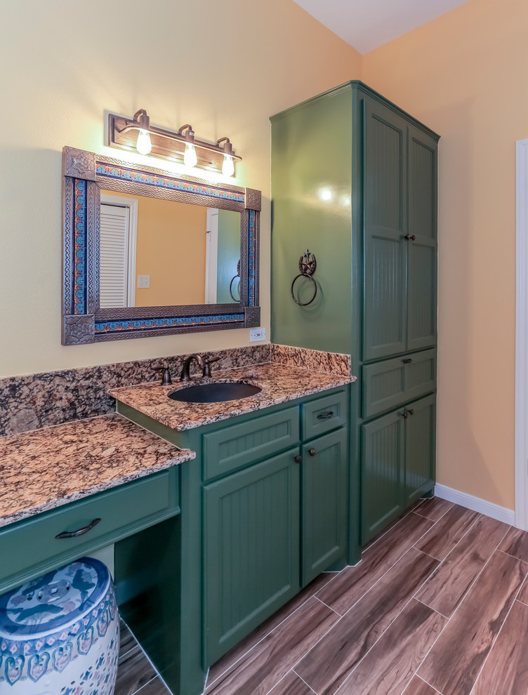 Exempel på ett stort amerikanskt en-suite badrum, med luckor med profilerade fronter, gröna skåp, en dubbeldusch, en toalettstol med separat cisternkåpa, brun kakel, porslinskakel, orange väggar, klinkergolv i porslin, ett undermonterad handfat och granitbänkskiva