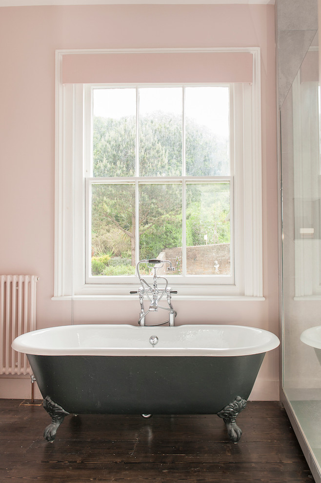 Ejemplo de cuarto de baño infantil romántico grande con bañera exenta, baldosas y/o azulejos blancos, baldosas y/o azulejos de cerámica, paredes rosas y suelo de madera oscura