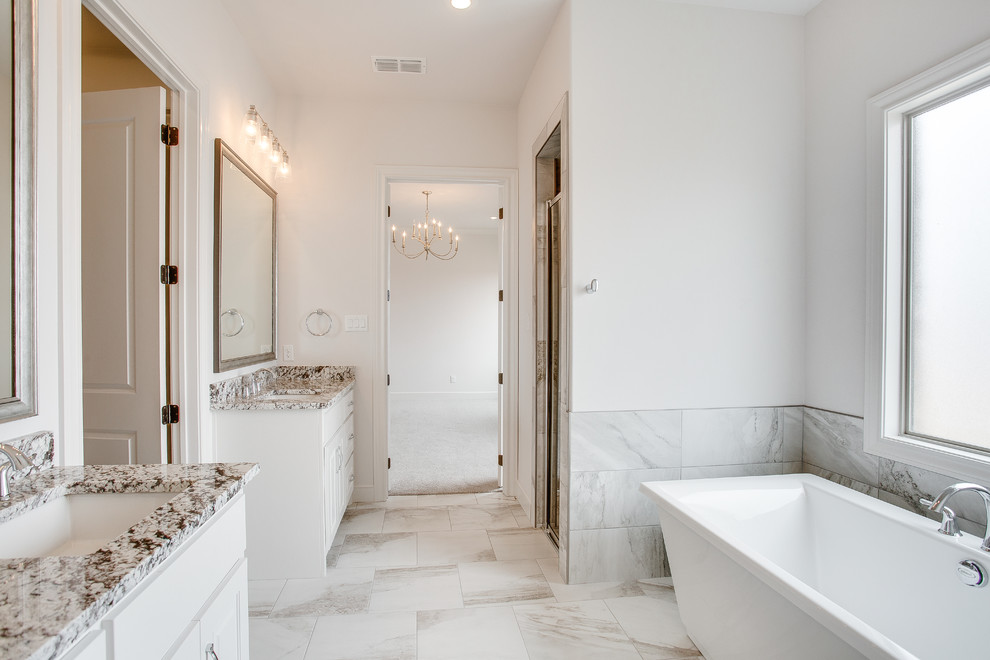 Bild på ett mellanstort vintage flerfärgad flerfärgat en-suite badrum, med luckor med upphöjd panel, vita skåp, ett fristående badkar, en dusch i en alkov, vita väggar, ett undermonterad handfat, granitbänkskiva, vitt golv och dusch med gångjärnsdörr