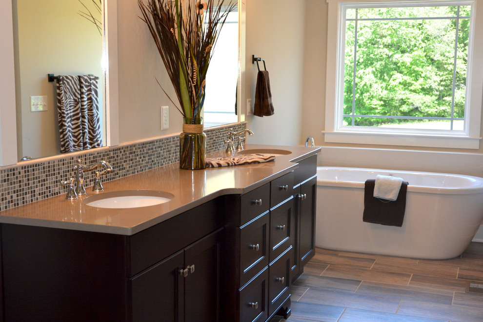 Example of a mid-sized arts and crafts master glass tile freestanding bathtub design in Other with an undermount sink, recessed-panel cabinets, dark wood cabinets and beige walls