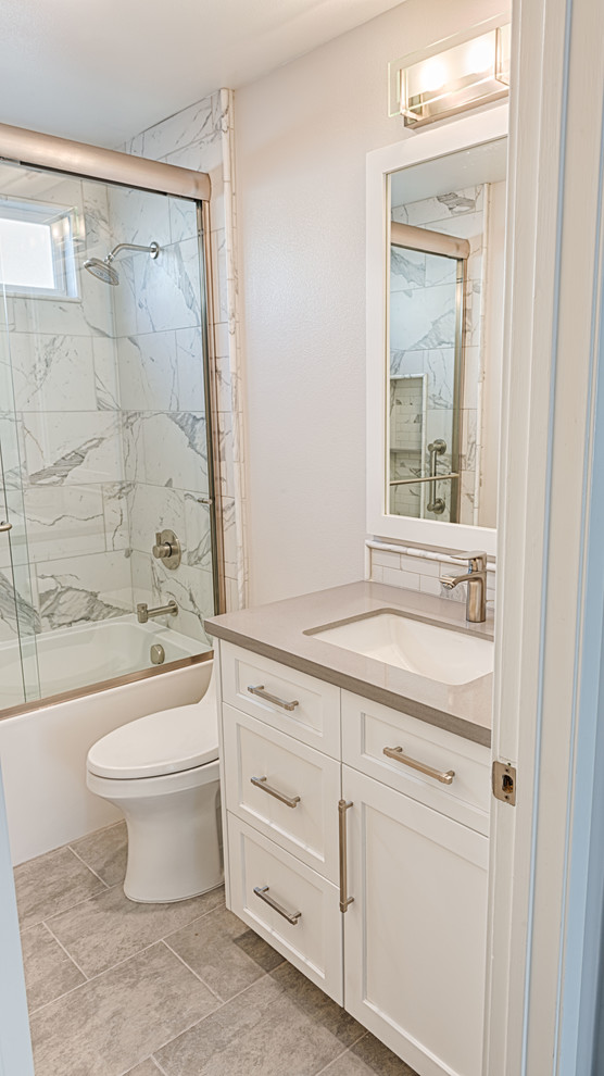 Small arts and crafts 3/4 porcelain tile and gray floor bathroom photo in Los Angeles with recessed-panel cabinets, white cabinets, a two-piece toilet, beige walls, an undermount sink, quartz countertops and gray countertops