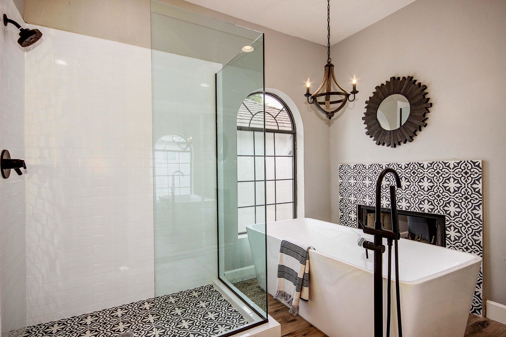 Exempel på ett stort medelhavsstil en-suite badrum, med ett fristående badkar, en hörndusch, dusch med gångjärnsdörr, svart och vit kakel, flerfärgad kakel, cementkakel, bruna väggar, mellanmörkt trägolv och flerfärgat golv
