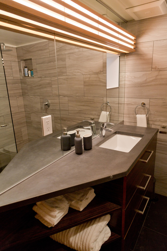 На фото: маленькая ванная комната в стиле модернизм с плоскими фасадами, темными деревянными фасадами, душем без бортиков, раздельным унитазом, серой плиткой, керамогранитной плиткой, серыми стенами, полом из керамогранита, душевой кабиной, врезной раковиной, столешницей из бетона, черным полом, открытым душем и черной столешницей для на участке и в саду