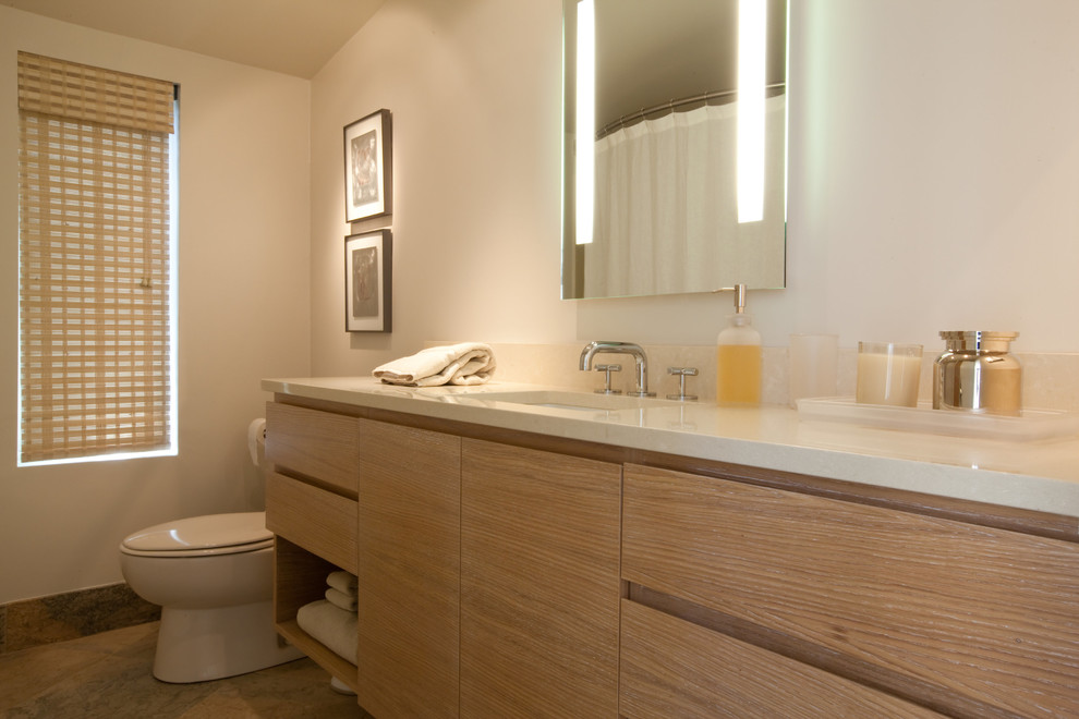 Источник вдохновения для домашнего уюта: огромная ванная комната в современном стиле с плоскими фасадами, светлыми деревянными фасадами, ванной в нише, душем над ванной, унитазом-моноблоком, белыми стенами, полом из травертина, врезной раковиной, столешницей из искусственного кварца, шторкой для ванной и бирюзовой столешницей