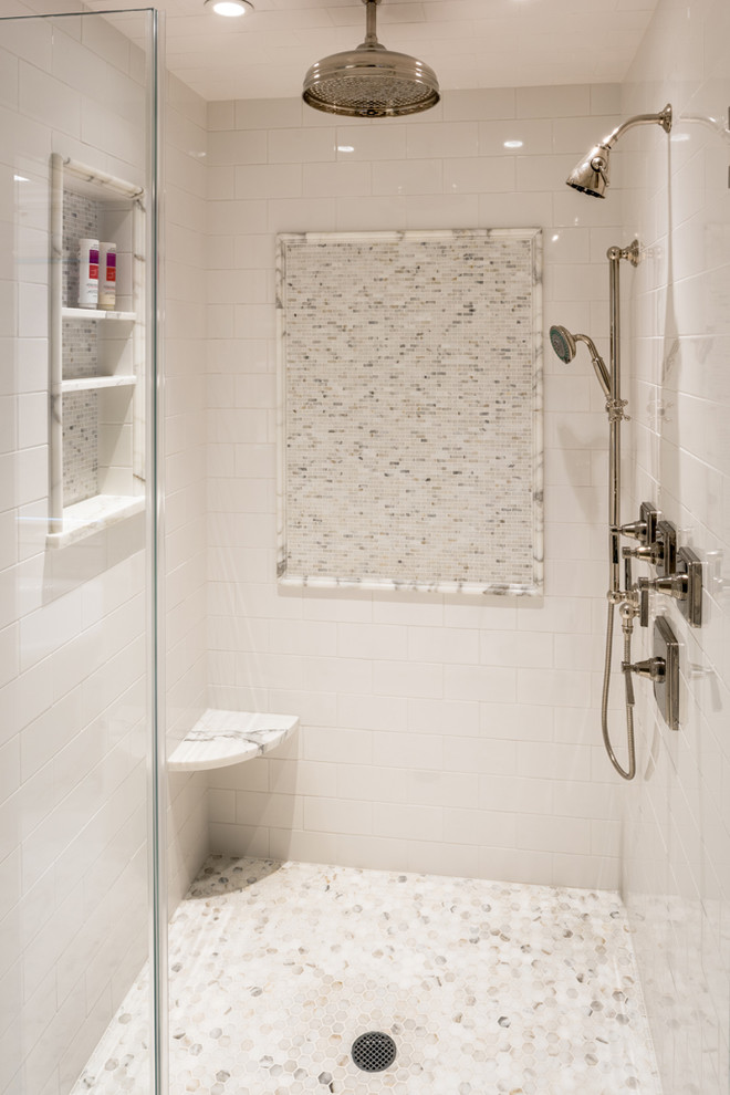 Klassisk inredning av ett en-suite badrum, med en dusch i en alkov, vit kakel, tunnelbanekakel, vita väggar och marmorgolv