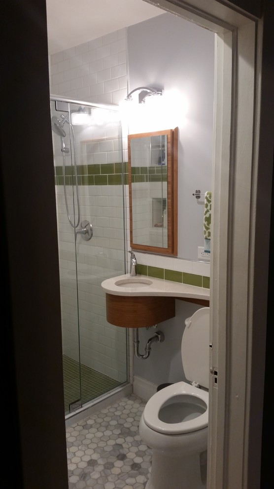 Small eclectic shower room bathroom in Other with a submerged sink, medium wood cabinets, solid surface worktops, an alcove shower, a two-piece toilet, green tiles, metro tiles, blue walls and marble flooring.