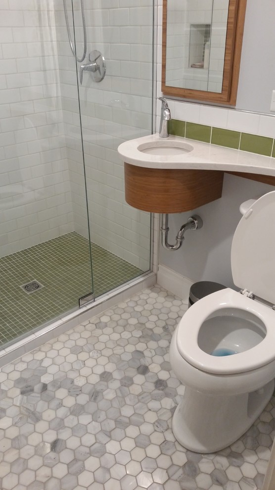 Foto på ett litet eklektiskt badrum med dusch, med ett undermonterad handfat, skåp i mellenmörkt trä, bänkskiva i akrylsten, en dusch i en alkov, en toalettstol med separat cisternkåpa, grön kakel, tunnelbanekakel, blå väggar och marmorgolv