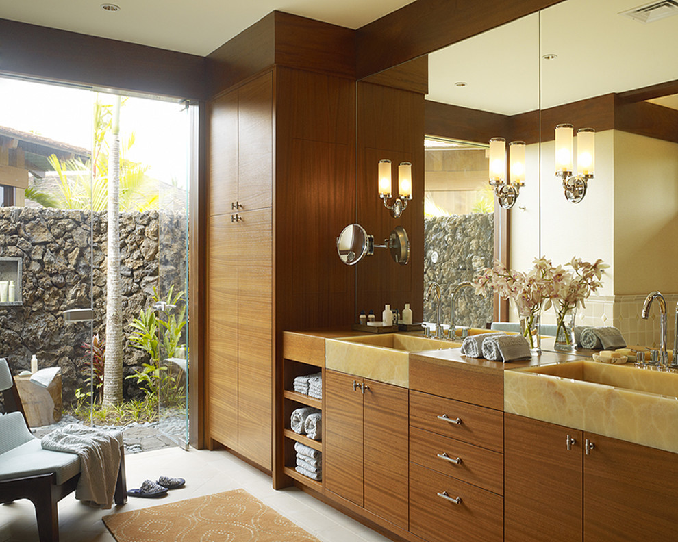 World-inspired bathroom in Hawaii with flat-panel cabinets, medium wood cabinets and feature lighting.