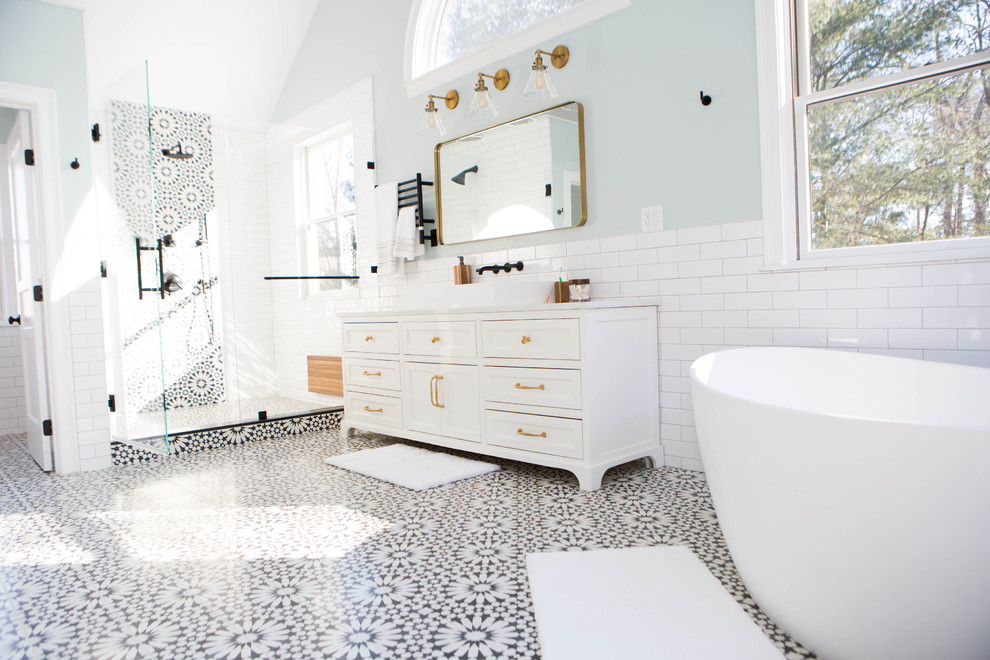 Inspiration for a large mediterranean master black and white tile and subway tile cement tile floor and black floor bathroom remodel in Boston with shaker cabinets, white cabinets, a two-piece toilet, blue walls, a vessel sink, marble countertops, a hinged shower door and white countertops