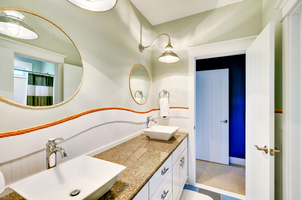 Foto de cuarto de baño costero con lavabo sobreencimera y puertas de armario blancas