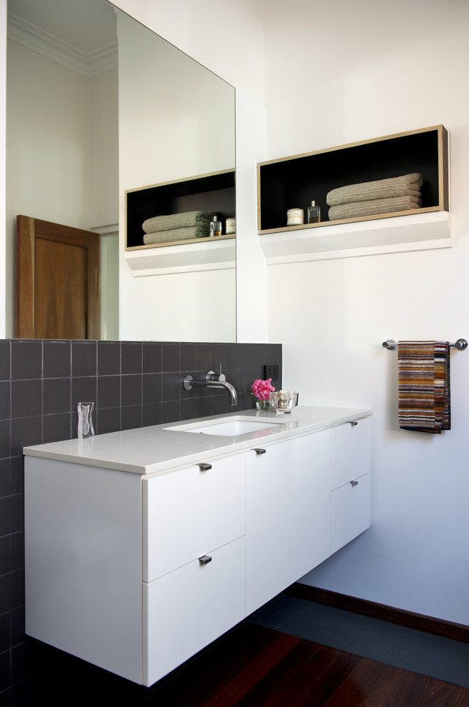 На фото: ванная комната в современном стиле с белыми фасадами и серой плиткой с