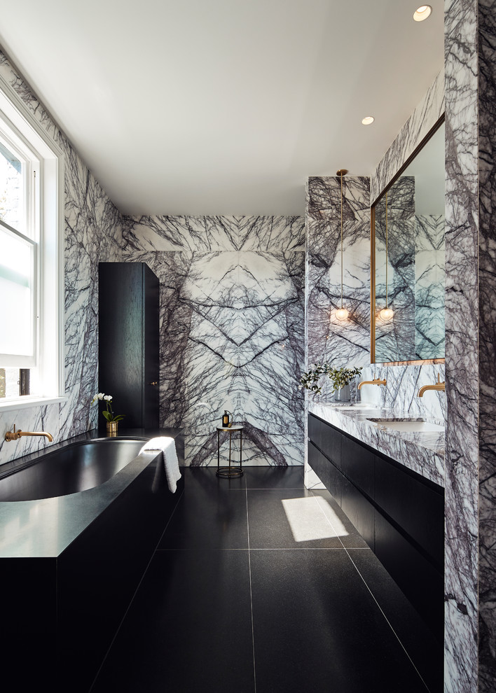 Inredning av ett modernt mellanstort flerfärgad flerfärgat en-suite badrum, med svarta skåp, ett undermonterat badkar, en dubbeldusch, marmorkakel, ett undermonterad handfat, marmorbänkskiva, svart golv, dusch med gångjärnsdörr, släta luckor och flerfärgad kakel