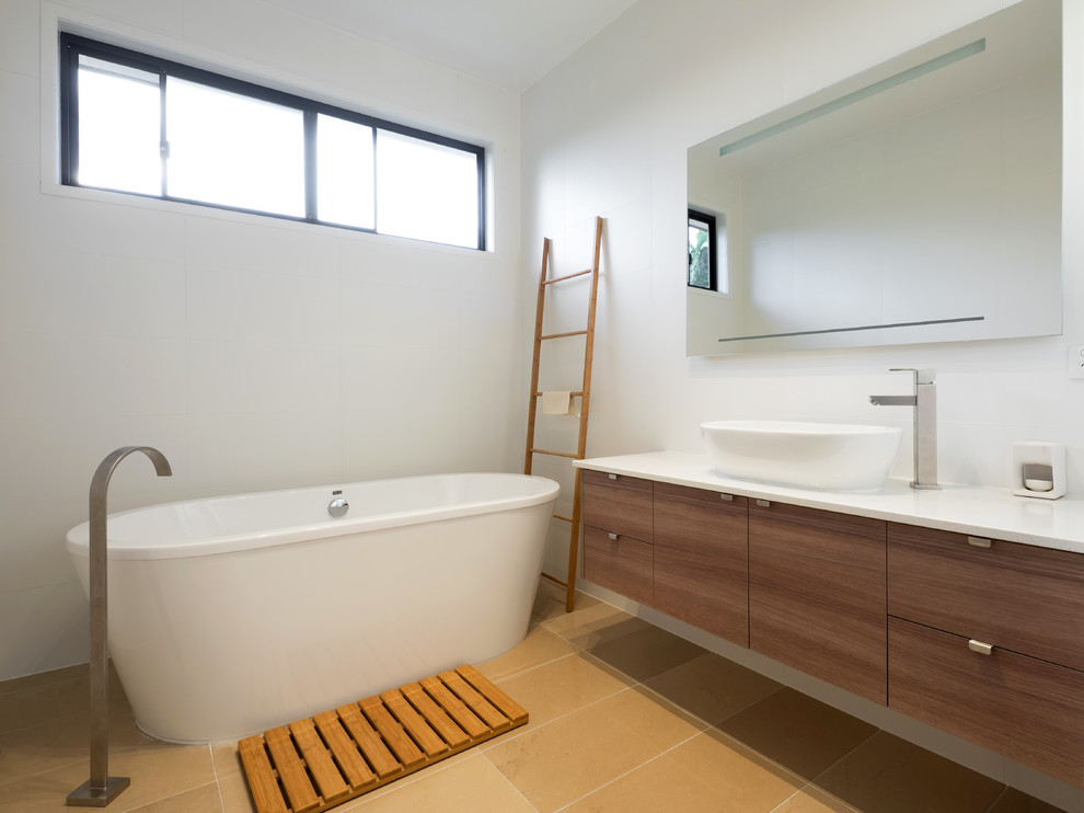Imagen de cuarto de baño contemporáneo con puertas de armario de madera oscura, bañera exenta, aseo y ducha, lavabo sobreencimera, suelo beige y encimeras blancas