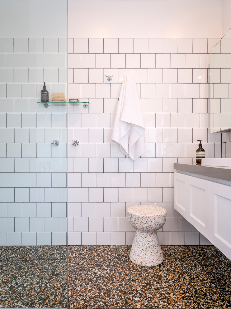 Inspiration for a mid-sized modern 3/4 white tile and ceramic tile terrazzo floor and black floor bathroom remodel in Melbourne with shaker cabinets, white cabinets, a two-piece toilet, white walls, a drop-in sink, quartz countertops and gray countertops